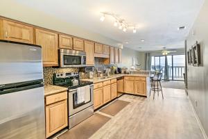 a kitchen with wooden cabinets and stainless steel appliances at Waterfront Escape with Balcony on Shell Point Beach! in Panacea