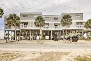 a large white building with palm trees in front of it at Waterfront Escape with Balcony on Shell Point Beach! in Panacea
