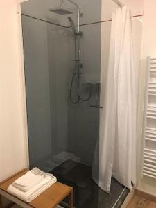a shower with a glass door and a table in a bathroom at Winnipeg in Colombiers-sur-Seulles