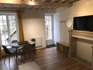 salon ze stołem i kominkiem w obiekcie Winnipeg w mieście Colombiers-sur-Seulles