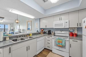 a kitchen with white cabinets and white appliances at High View in Avon