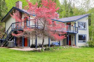 a house with a flowering tree in front of it at Tahuya Cabin Hood Canal and Olympic Mountain Views! in Tahuya