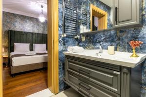 a bathroom with a sink and a bed at BayMari Suites Plus Florya in Istanbul