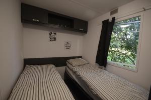 2 łóżka w małym pokoju z oknem w obiekcie Owls Camp w mieście Karwieńskie Błoto Drugie