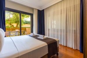 a bedroom with a bed and a large window at BayMari Suites Plus Florya in Istanbul