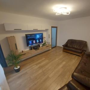 ein Wohnzimmer mit einem Sofa und einem Flachbild-TV in der Unterkunft Apartament AntoniaS in Făgăraş