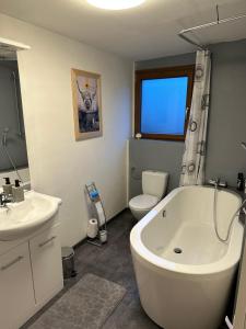 ein Badezimmer mit einer Badewanne, einem WC und einem Waschbecken in der Unterkunft Gîte des vignes in Bremis