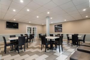 a dining room with tables and chairs and a tv at SureStay Hotel by Best Western Columbus Downtown in Columbus
