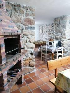 a living room with a stone fireplace and a table at O Lar do Suso 
