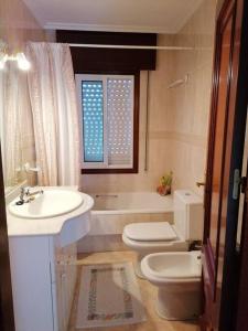 a bathroom with a sink and a toilet and a tub at O Lar do Suso 