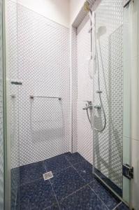 uma casa de banho com um chuveiro e uma porta de vidro em Студио Римски Стадион em Plovdiv