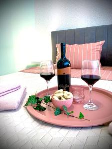 einen Tisch mit zwei Gläsern Wein und einem Teller Essen in der Unterkunft Студио Римски Стадион in Plowdiw