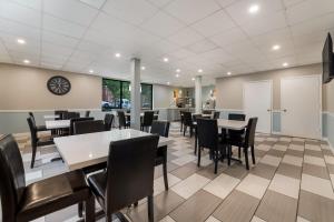 a dining room with tables and chairs and a clock on the wall at SureStay Hotel by Best Western Columbus Downtown in Columbus