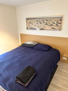 - une chambre avec un lit bleu et une serviette dans l'établissement Luxurious and cosy loft - Knokke, à Knokke-Heist