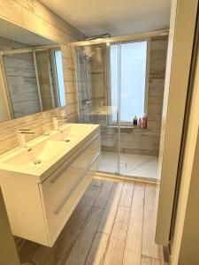 La salle de bains est pourvue de 2 lavabos et d'une douche en verre. dans l'établissement Luxurious and cosy loft - Knokke, à Knokke-Heist