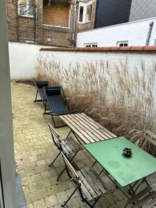 d'une terrasse avec 2 chaises et une table et des chaises vertes. dans l'établissement Luxurious and cosy loft - Knokke, à Knokke-Heist