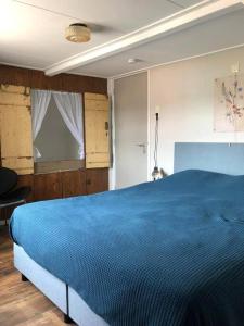 a bedroom with a blue bed in a room at De Scheve Deur in Vollenhove