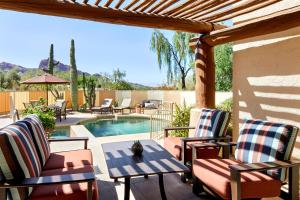 a patio with chairs and a table and a pool at JW Marriott Scottsdale Camelback Inn Resort & Spa in Scottsdale
