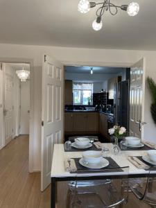 a kitchen with a table with plates on it at Large Bed in a luxuriously furnished Guests-Only home, Own Bathroom, Free WiFi, West Thurrock in Grays Thurrock