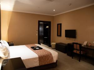 a hotel room with a bed and a flat screen tv at Hotel Casino Magic in Neuquén