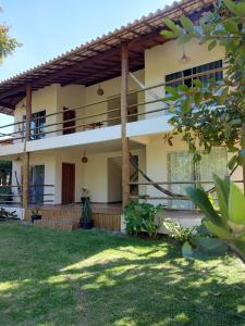 a house with a balcony and a yard at Flats Maui in Barra Grande