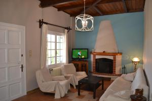 sala de estar con sofá y chimenea en Villa “Serenity”, en Agios Leon