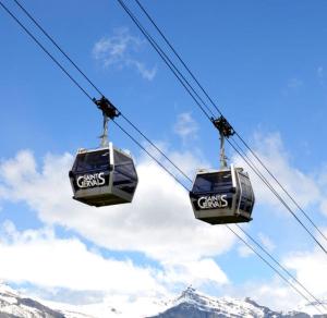 two gondolas on a ski lift with mountains in the background at Saint-Gervais-les-Bains, Appartement 4 personnes in Saint-Gervais-les-Bains