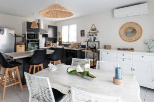 a kitchen with a table and chairs in a room at Agréable maison avec extérieur in Parentis-en-Born