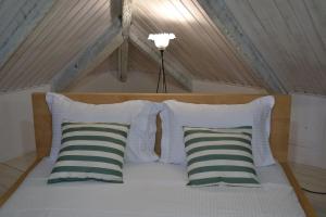 una cama con 4 almohadas y una lámpara en el ático en Villa “Serenity”, en Agios Leon