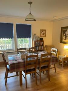 a dining room with a table and chairs and a table and chairsktop at Sidhean Dubha Holiday Home in Portree