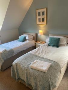 Un dormitorio con dos camas con almohadas azules. en Sidhean Dubha Holiday Home, en Portree 37 fotos más