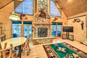 a dining room with a table and a fireplace at Iron River Cabin Rental with Fireplace and Deck! in Iron River