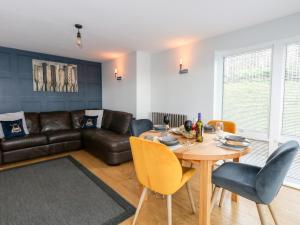 a living room with a table and a leather couch at Pointers View in Weymouth