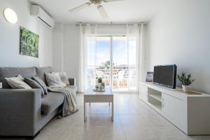 a living room with a couch and a tv at Alea Rentals - Acquamarina in La Pineda