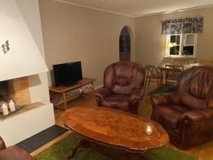 a living room with leather chairs and a coffee table at Naturnära hus utanför Reftele närhet till Isaberg och High Chaparral in Reftele