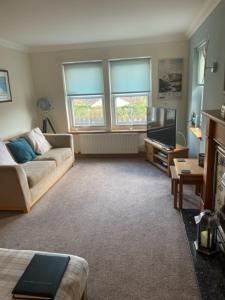 a living room with a couch and a tv at Sidhean Dubha Holiday Home in Portree