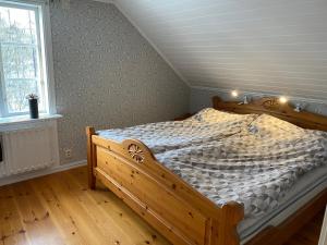 um quarto com uma cama de madeira num sótão em Naturnära hus utanför Reftele närhet till Isaberg och High Chaparral em Reftele