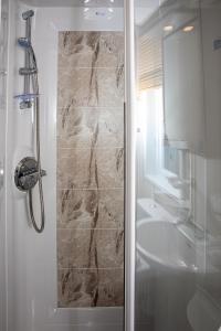 a bathroom with a shower and a sink at Nature Haven Hot Tub Lodge 30 Cameron, St Andrews in St. Andrews +24 photos