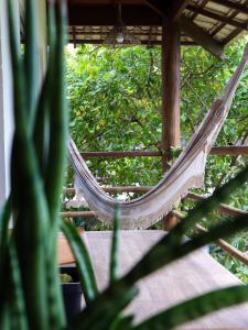 un hamac suspendu à une terrasse couverte avec une plante dans l'établissement Flats Maui, à Barra Grande