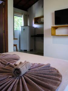uma toalha sentada numa cama num quarto em Flats Maui em Barra Grande