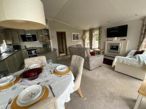 uma cozinha e sala de estar com mesa e cadeiras em Lakeview Lodge em Wisbech