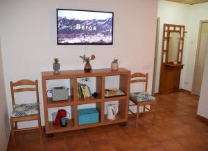 a living room with two chairs and a tv on the wall at Apartamentos loli in Berga