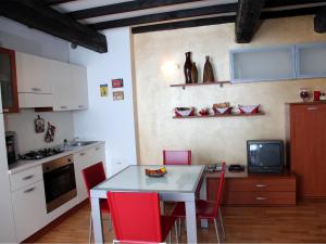 cocina con mesa blanca y sillas rojas en Il Sipario, en Ferrara