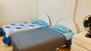 2 camas en una habitación de color azul y blanco en Departamento Avenida Bolognesi Tacna, en Tacna