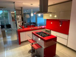 uma cozinha com armários vermelhos e um forno com placa de fogão em Villa Giuliano no Hibiscus Beach Clube Ipioca Maceio em Maceió
