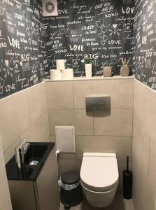 uma casa de banho com WC e escrita na parede em Csengery Apartment em Budapeste