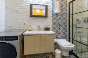 a bathroom with a sink and a toilet and a mirror at BayMari Suites Plus Florya in Istanbul