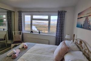 a bedroom with a bed with two stuffed animals on it at Waterfront - Holes Bay, Poole, Dorset in Hamworthy