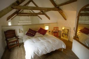 a bedroom with a white bed and a mirror at Lower Godney Little House in Wells