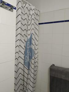 uma cortina de chuveiro numa casa de banho com uma placa em Studio Climatisé Résidence Odalys Saint Loup,piscine ,parking privé et superette em Cap d'Agde